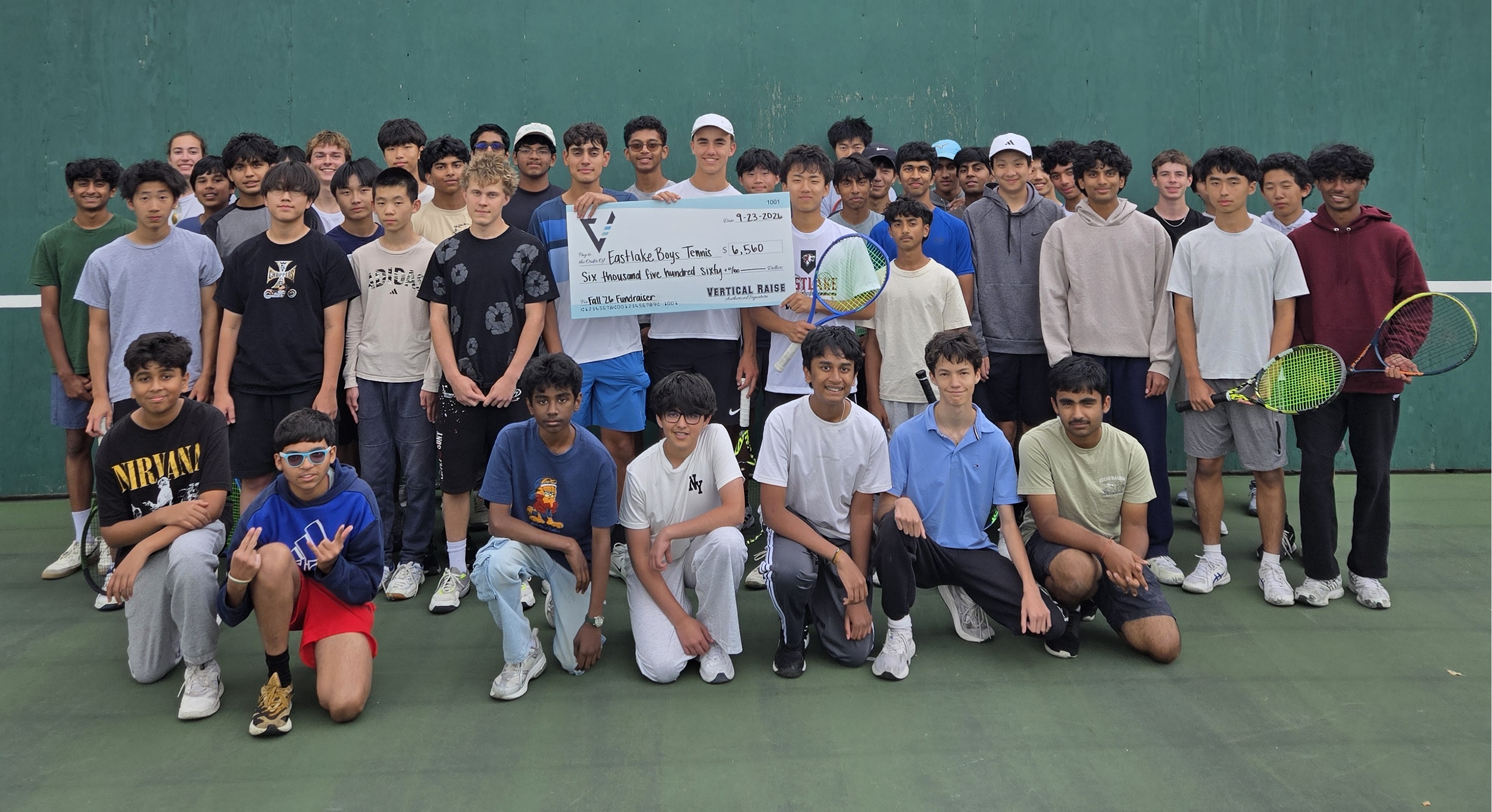 Eastlake Boys Tennis players posing with a fundraiser donation check